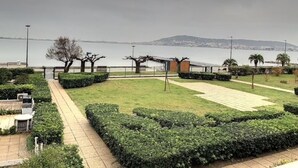 A landscaped garden with a paved walkway, neatly trimmed hedges, and a view of the sea. - Cozy apartment near Thermes with balcony, pets allowed (Balaruc-les-Bains)