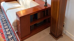 A room with a sofa, a bookshelf, two lamps, a framed artwork, and a patterned rug. - Homerez - House in Reignier-Esery (Reignier-Esery)
