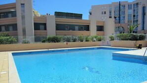 Une piscine rectangulaire à l’eau d’un bleu limpide, entourée d’une terrasse carrelée.