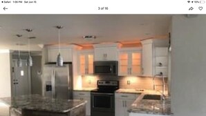 A modern kitchen with granite countertops, stainless steel appliances, and pendant lighting. - Beautiful View of Intersecting Canals from the Moment You Walk In (Cape Coral)