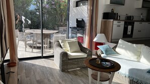 Una sala de estar moderna con un amplio ventanal corredera que da a un patio exterior.
