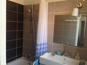 Bathtub, hair dryer, towels, toilet paper