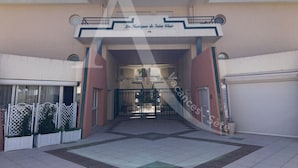 The entrance to Les Nautiques de Saint Clair, featuring a central gate, a covered walkway, and a building facade with a sign. - 2 CHAMBRES, LARGE TERRASSE, 1ERE LIGNE MER (Sète)