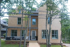A two-story house with a covered porch, large windows, and a front door.