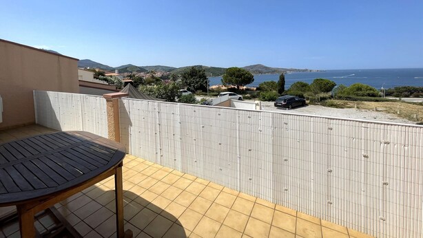 A balcony with a view of the sea, a wooden table, and a tiled floor. - T3 Apartment in Banyuls-sur-Mer, terrace and private parking (Banyuls-sur-Mer)