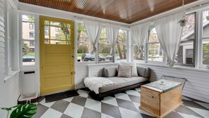 Une pièce chaleureuse avec un sol à carreaux, un banc en bois et une porte jaune.