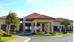 A hotel with a central courtyard, palm trees, and a red-tiled roof. - Casa de Pauline - Noord (Noord)