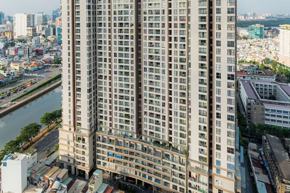 Ein Hochhaus mit mehreren Etagen, umgeben von anderen Gebäuden und einem Fluss.