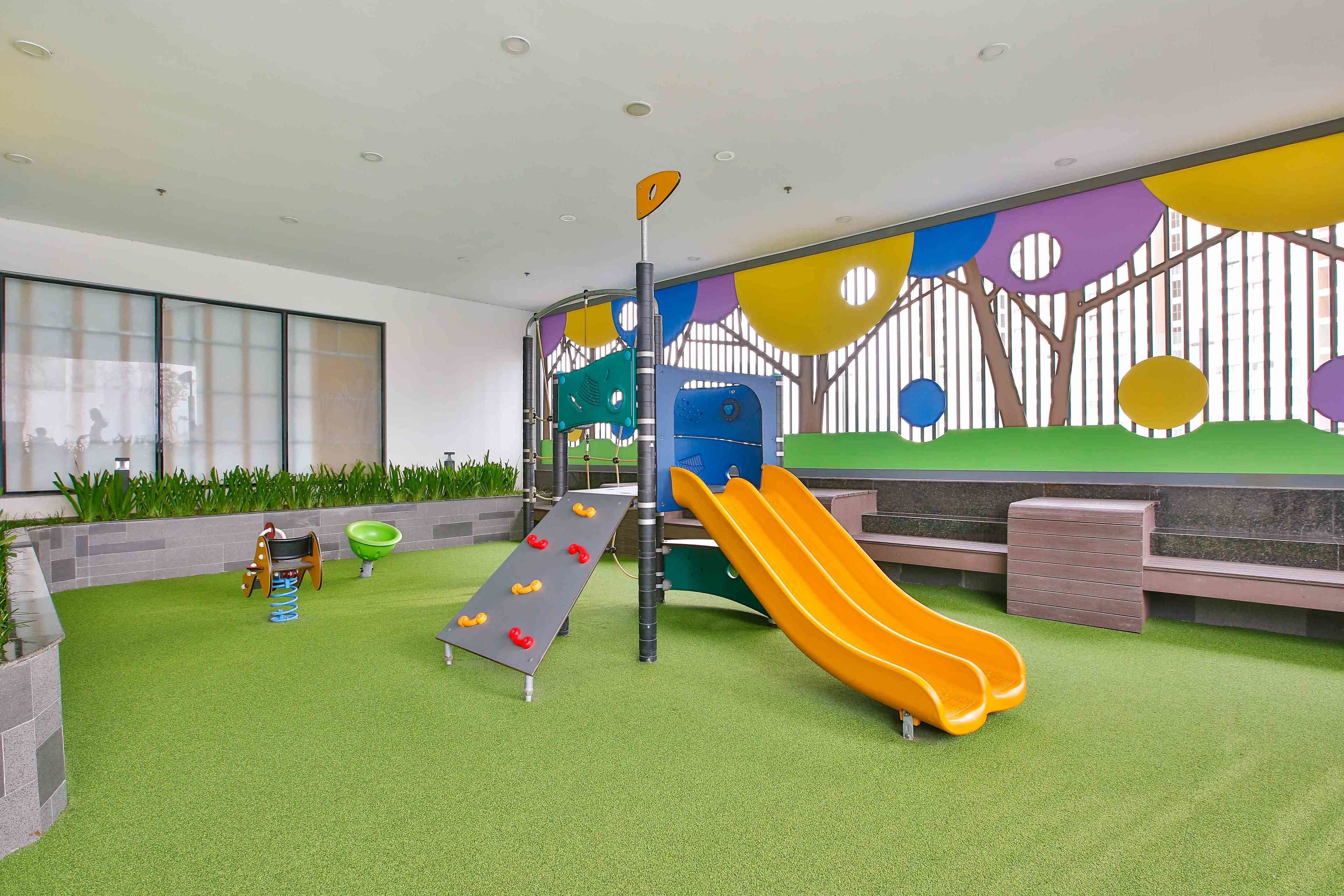 A children's play area with a slide, climbing wall, and soft play equipment.