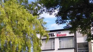 Un hotel llamado 'Los Baisos' con una fachada moderna, múltiples ventanas y una entrada visible.