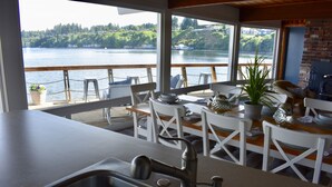 Une cuisine avec vue sur un lac, des chaises longues en bois et une table à manger.
