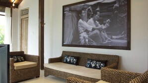Una habitación con una fotografía grande en blanco y negro en la pared, un sofá con cojines estampados y un televisor sobre un mueble.