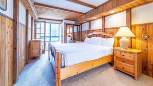 A wooden bedroom with a large bed, bedside tables, and a window. - Retreat at Canyon Lodge w/ Mountain Views! (Mammoth Lakes)
