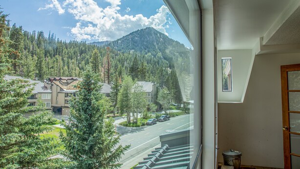 A view from a window overlooking a residential area with houses, a road, and a mountain. - Retreat at Canyon Lodge w/ Mountain Views! (Mammoth Lakes)