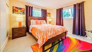 A bedroom with a bed, nightstands, a colorful rug, and curtains. - #4 ❤️ Sunny, Newly Furnished 1BR apt (Fort Lauderdale)