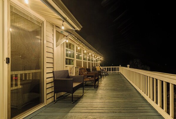 Terraza cubierta al aire libre con asientos y luces colgantes.
