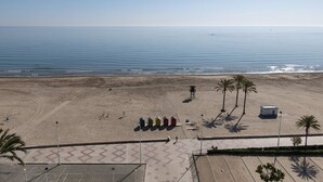 A beach with a clear view of the ocean, a paved walkway, and a few palm trees. - LIDER, 10-B (Cullera)