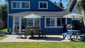 A two-story blue house with a patio area featuring outdoor furniture and a covered seating area. - Amazing Waterfront, Cottage at Big Bay Point (Innisfil)
