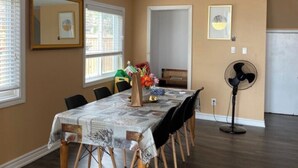 A dining area with a long table, chairs, and a fan. - Amazing Waterfront, Cottage at Big Bay Point (Innisfil)