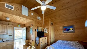 A wooden cabin interior with a kitchen, dining area, and a bedroom. - Get hooked on "The Fish House"! (HATTERAS)