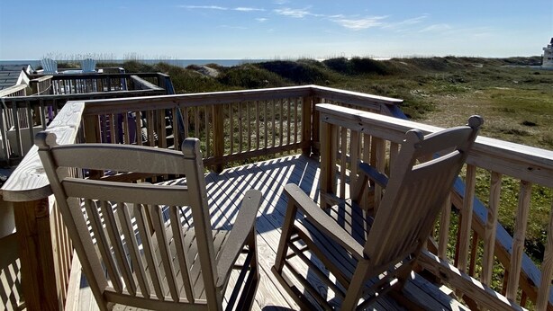 A wooden deck with chairs overlooking a beach and dunes. - Get hooked on "The Fish House"! (HATTERAS)