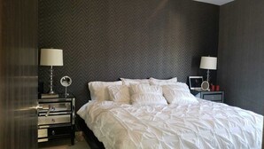 A neatly made bed with white bedding, two bedside tables with lamps, and a mirror on one table. - Comfortable private room (Lomas de San Francisco)
