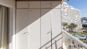 Ein Balkon mit Blick auf ein großes Hotelgebäude und einen Swimmingpool.