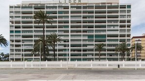 Ein mehrstöckiges Gebäude mit der Aufschrift "LIDER" oben. Es besitzt mehrere Balkone und scheint ein Hotel oder ein Mehrfamilienhaus zu sein.
