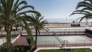 Ein Tennisplatz mit Blick auf Strand und Meer.