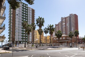 A multi-story residential building with balconies, palm trees, and a clear sky. - MONTEMAR, C-12º-33 (Cullera)