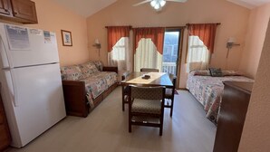 A compact room with a kitchenette, a dining table, and two beds. - A Dune Away is the place to stay! (HATTERAS)