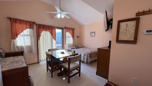 A room with a dining table, two beds, a ceiling fan, and a framed picture on the wall. - A Dune Away is the place to stay! (HATTERAS)