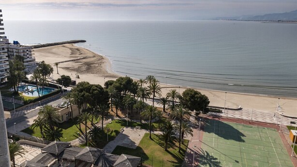 Un hôtel situé sur la côte, avec vue sur la plage, une piscine et un court de tennis.