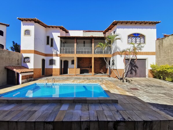 A two-story building with a swimming pool in the foreground.