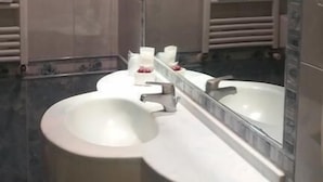 Ein Badezimmer mit zwei Waschbecken, einem großen Spiegel und Handtuchhaltern.