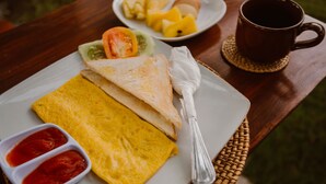 A breakfast plate with toast, scrambled eggs, and a side of ketchup. - Arie Guest House Nusa Penida (Penida Island)