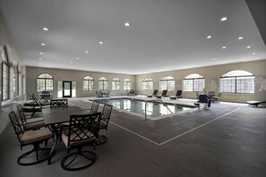 A spacious indoor swimming pool area with multiple seating arrangements and large windows. - Staybridge Suites Holland by IHG (Holland)