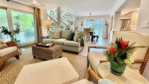 A spacious living room with a sofa, coffee table, and a dining area in the background. - Island Song Villa - Newly Renovated, Pool, Tennis & Pickleball, Prime Location (Hilton Head Island,)