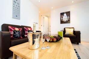 Ein modernes Wohnzimmer mit einem Holztisch, einer Champagnerflasche und zwei Gläsern.