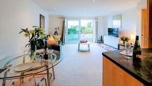 A modern kitchen with a glass dining table, a sofa, and a TV. - A modern apartment, equipped with everything for a comfortable stay (Portsmouth)