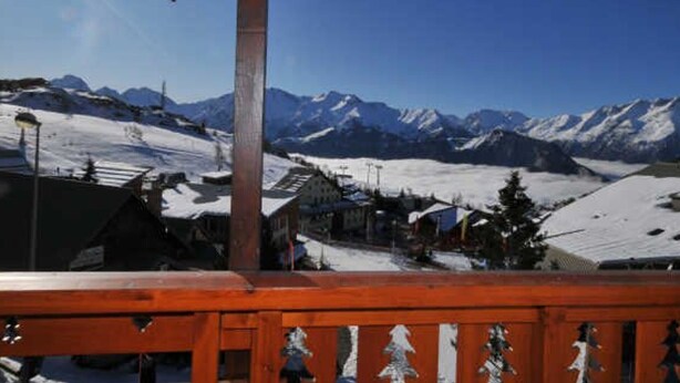 A wooden balcony with snow-covered mountains in the background. - Cozy Duplex for 5, Close to Ski Lifts & Shops, South-Facing Balcony – Alpe d'Huez (Huez)