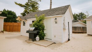 Een klein, gelijkvloers huis met een schuin dak, een voortuin en een kleine aaneengebouwde garage.