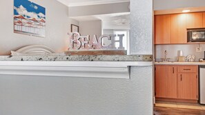 Enjoy cooking in this kitchen with a countertop sign reading 'BEACH' and a window offering a view.