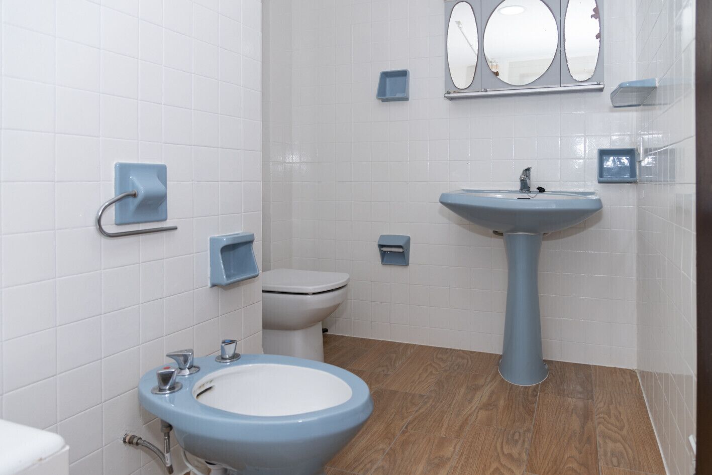 A bathroom with a toilet, a sink, and a bidet.