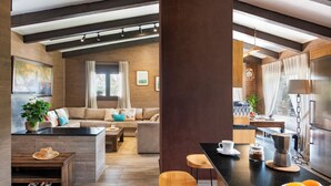 A modern kitchen with a central island, wooden flooring, and a dining area with bar stools. - Rural house surrounded by mountains with swimming pool, skatepark and children's playground in Llerena (Ribera de los Molinos, Llerena)