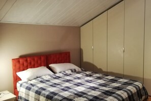 A bedroom with a bed, a nightstand, and a wardrobe. - full-equipped flat in the city center of Pescara (Pescara)