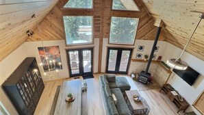 Un vaste espace de vie de style loft, doté d’un haut plafond, de grandes fenêtres, d’un coin salon confortable, d’une cheminée et d’un téléviseur.