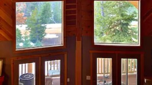 Une cabane dotée d’un toit en pente et de deux grandes fenêtres.