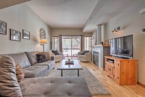 Relax in this stylish living room with a leather sofa, fireplace, and large window.