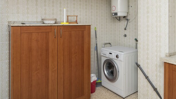 A laundry room with a washing machine, a wooden cabinet, and a water heater. - LIDER, 2-G (Cullera)